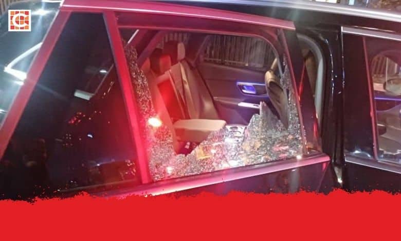 A luxury black vehicle with broken backseat window.