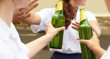 Young female learner turning down alcohol in response to peer pressure.