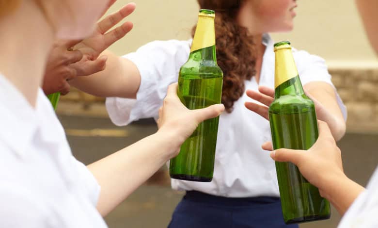 Young female learner turning down alcohol in response to peer pressure.