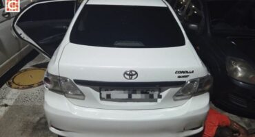 The recovered white Toyota Corolla with its doors open.