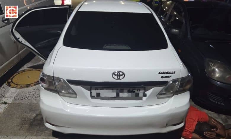 The recovered white Toyota Corolla with its doors open.