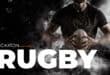 Man in black rugby jersey holding a rugby ball with the word ruby written in white at the bottom of the image