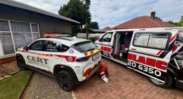 A first responder car and ambulance with its door open parked in front of a house.