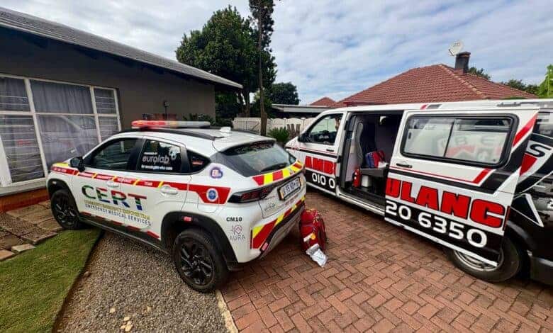 A first responder car and ambulance with its door open parked in front of a house.