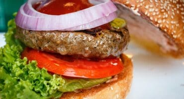 Flame-grilled ostrich burgers with classic toppings