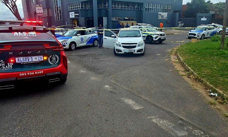 A street view with crime scene tape and various emergency vehicles visible