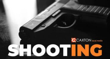 Photo of a pistol lying on a smooth dark surface with the word Shooting at the bottom of the image