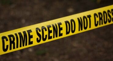 Yellow crime scene tape across a dark background