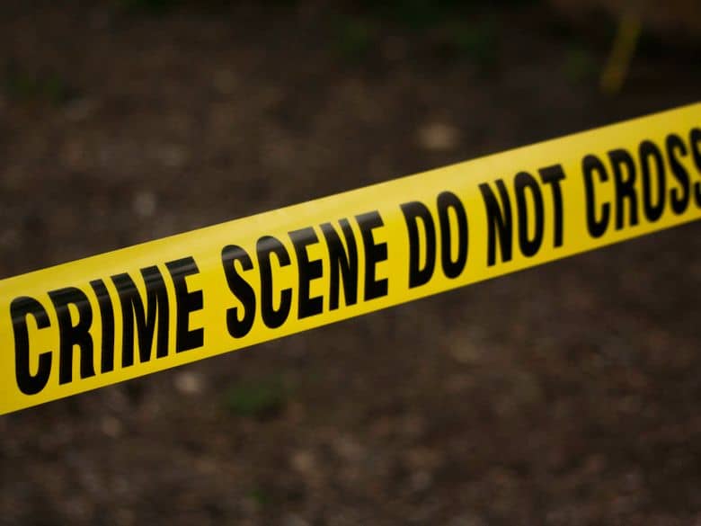 Yellow crime scene tape across a dark background