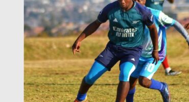 A soccer player is dribbling the ball.