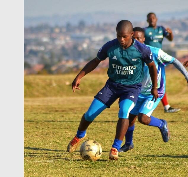 A soccer player is dribbling the ball.