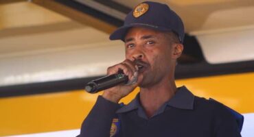 Police officer speaking at Soweto Urban community event, engaging residents and promoting safety awareness.