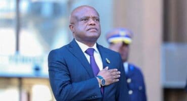 Respectful man in formal attire at a busy Soweto Urban event.