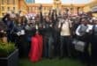 Students celebrate while holding newly received smartphones during a school handover event.