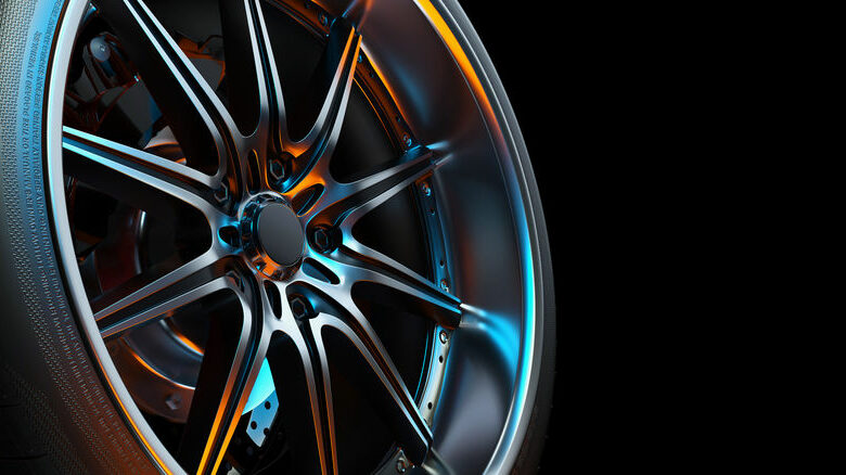Close-up photo of a car wheel in the black background studio.