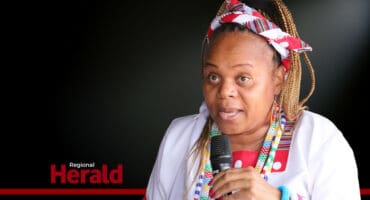 Limpopo Premier Dr Phophi Ramathuba in traditional attire with a black background,