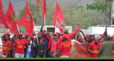 EFF members march with flags and their iconic red outfits.
