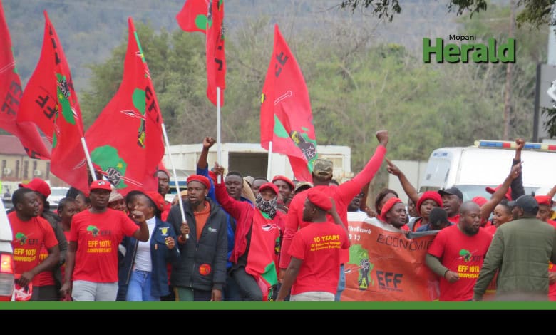 EFF members march with flags and their iconic red outfits.