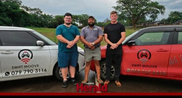 Pieter Grobler, Christo Lombard and Fanie van Hansen stand in front of the two cars they use as a taxi service.