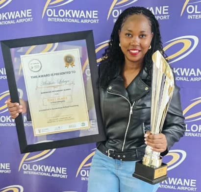 Regina Lebeya holds her certificate and trophy.