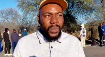 Macduff Mathebula speaks on the topic while small crowds stand in the background.