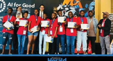 The Palabora Foundation robotics team stands on stage with their prizes.