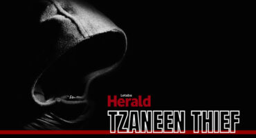 A hooded figure in the dark with the words "Tzaneen Thief".