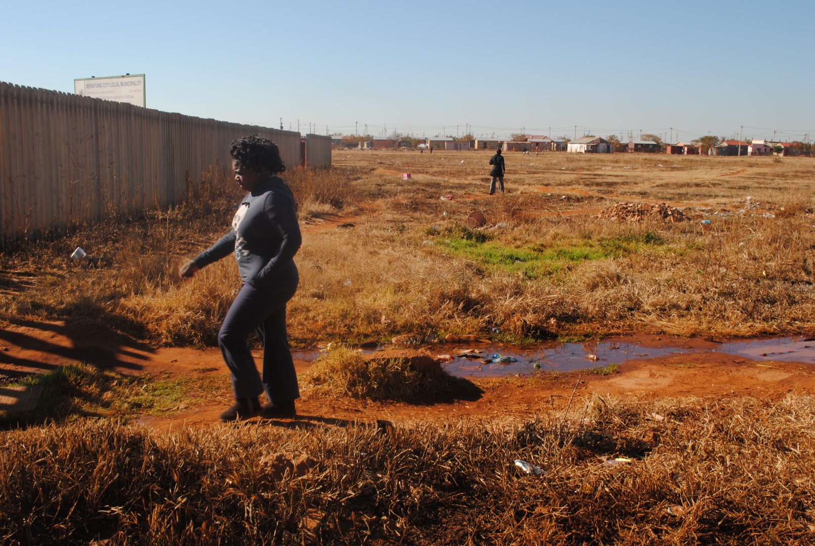 Residents walk past the dangerous open space.