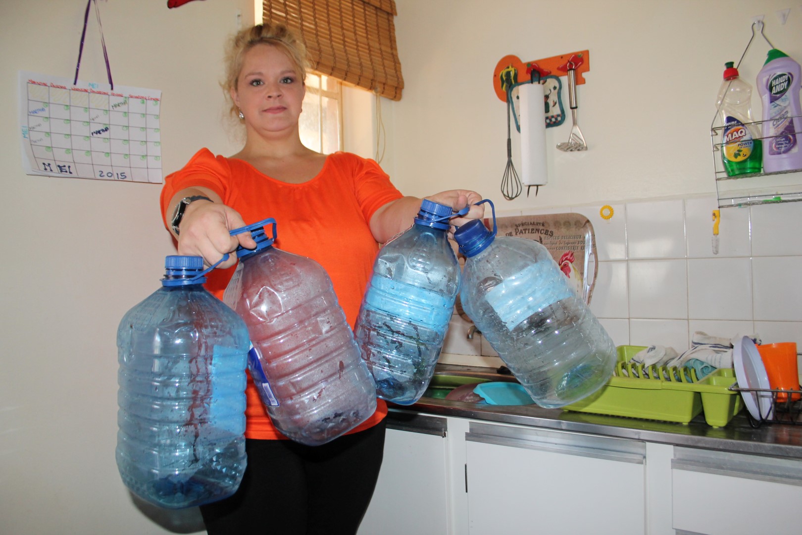 Mev. Lezandra du Plessis wys 'n paar van die waterbottels wat vinnig leeg geword het, net deur om in haar gesin se basiese waterbehoeftes te voorsien.