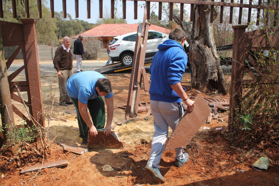 Bystanders picking up some pieces of the broken wall.