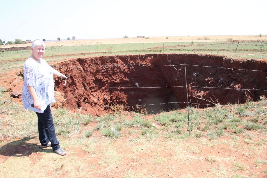 Ms Judy Rossouw at the sinkhole next to the road that will be repaired.