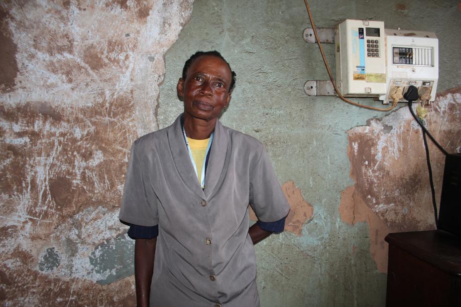 Ms Jeanette Mofokeng in front of her living room wall of which half the plaster had been removed.