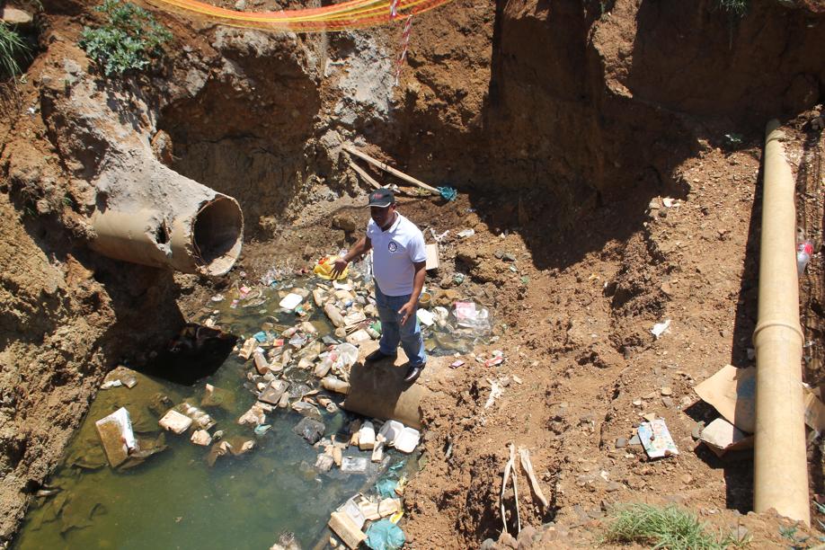 Mr John Tswasong in one of the deep holes left open by municipal contractors in Kokosi.