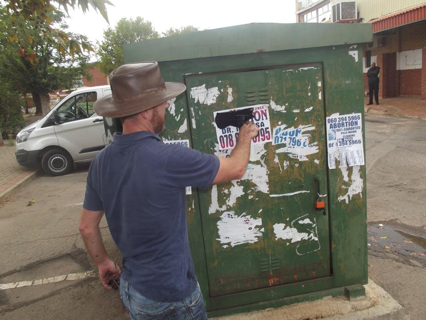 Anonymous man painting the illegal abortion flyers