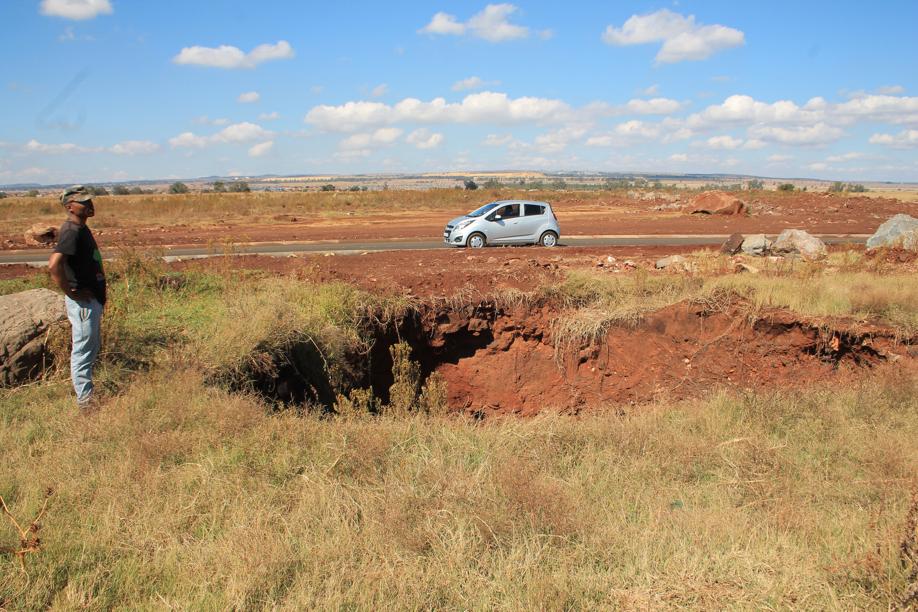 Mr Chucku Kerileng at the sinkhole next to the new road.