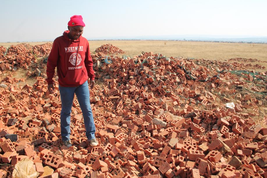 Ndubatha at some of the seemingly wasted bricks.