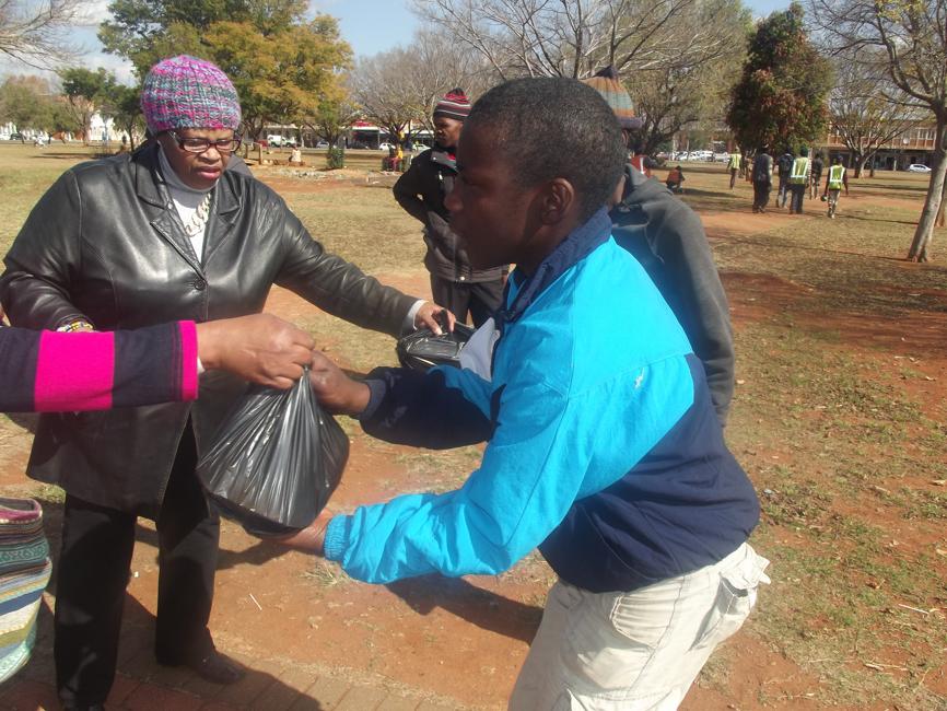 A member of Katlego ka Kgatelelo giving out food to the homeless