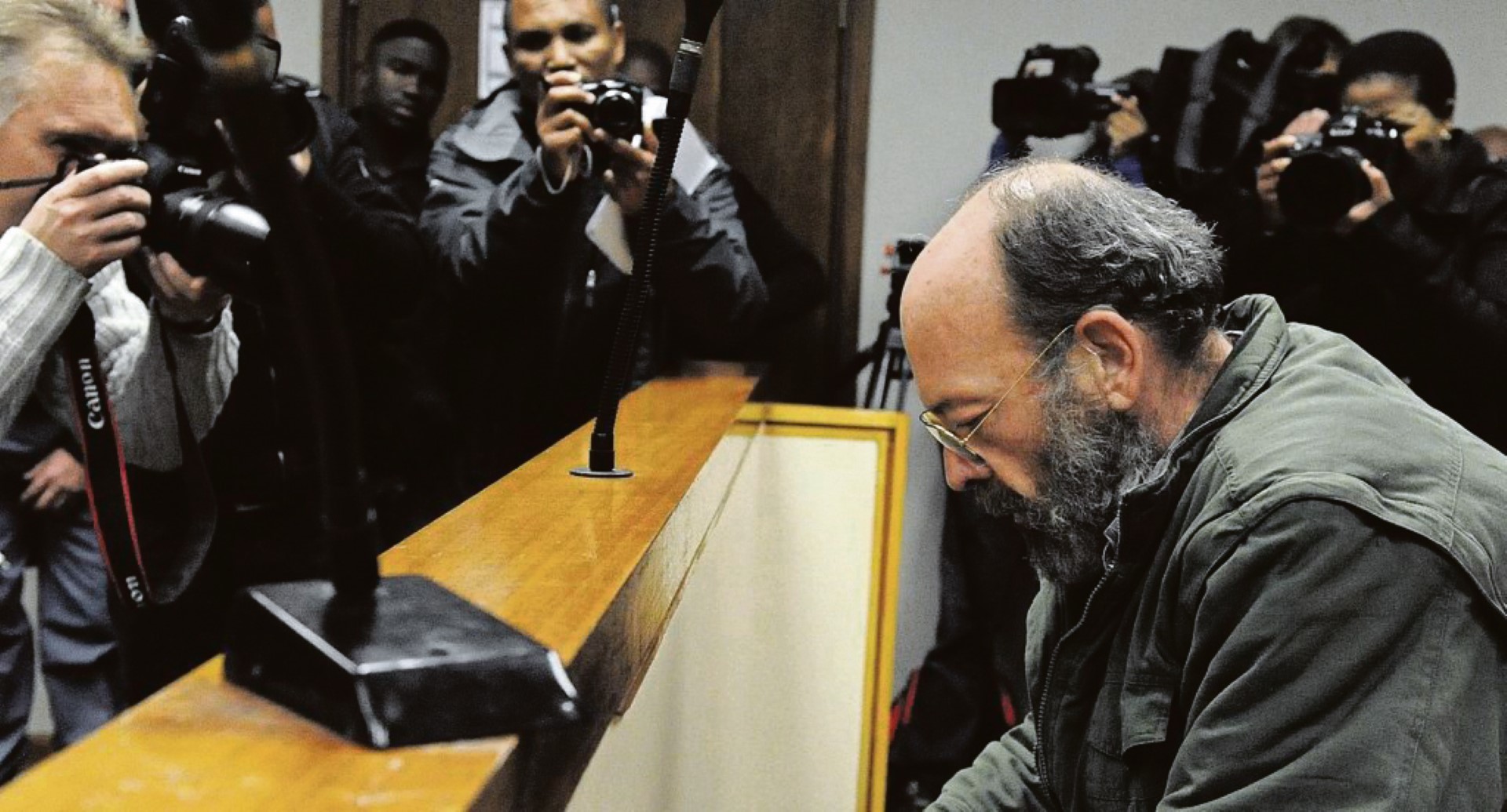 Photographers descend on former Vereeniging police colonel Christiaan Prinsloo in the Bellville Magistrates Court where he was sentenced to 18 years imprisonment for stealing weapons and selling it to gangsters in the Western Cape. Photo: Jonathan Lestrade/Son