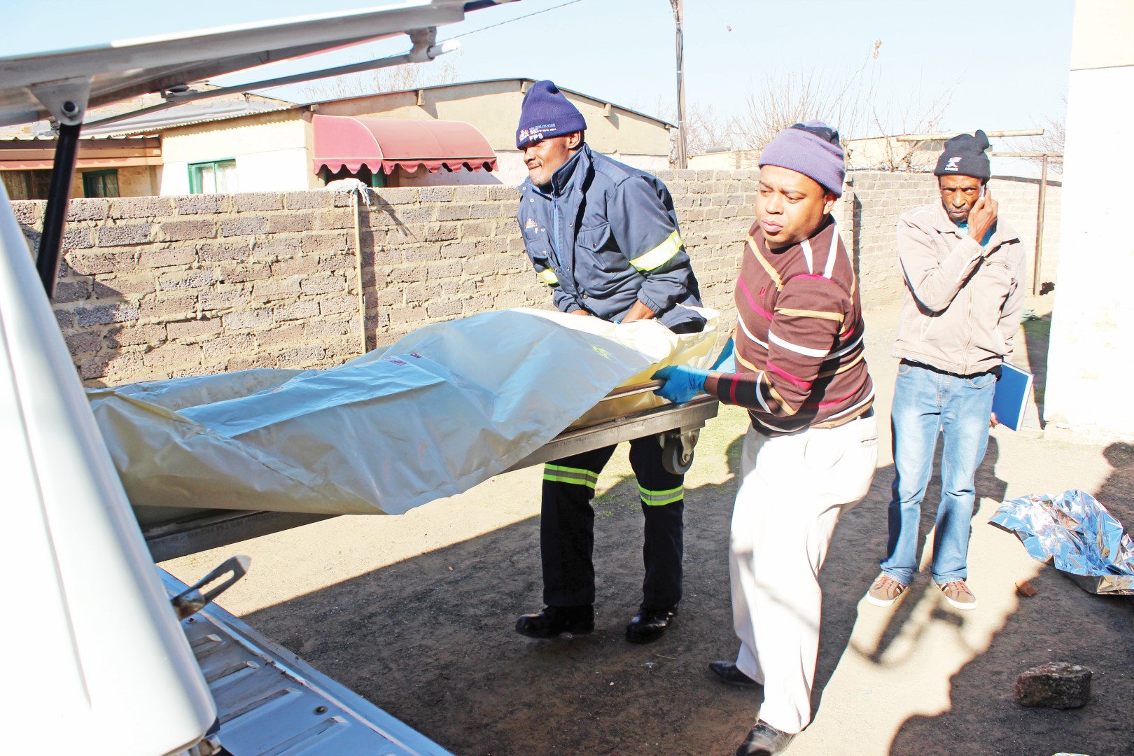 The lifeless body of Neo Mokopanelo is loaded into a pathology services vehicle on Saturday after he was gunned down.