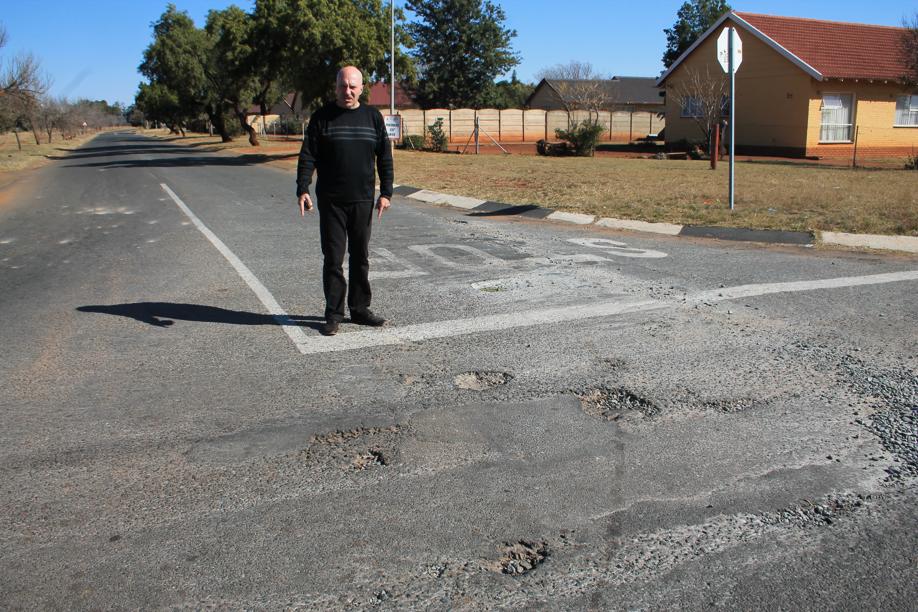 Mr Carlos Rebelo at the crossing of Baard and Grundling Streets that is lined with potholes.
