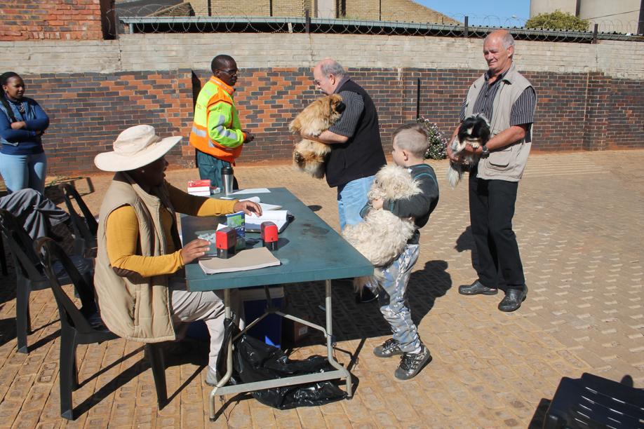 Many residents brought their pets to be vaccinated on Tuesday. Here Ms Keabetwe Ngoetjana of the State Veterinarian's office in Randfontein assisted a family with the vaccination documents for their diogs.