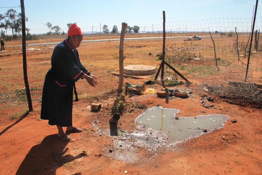 Ms Lolo Phetu at the pipe spewing sewage into her back yard.