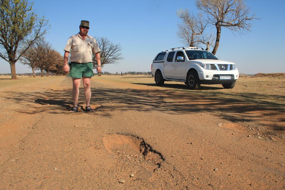 Mnr. Ben van den Berg by van die grootste slaggate op die pad na die begraafplaas.