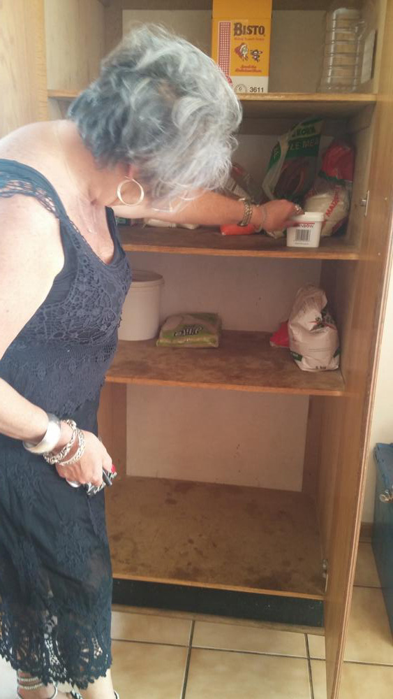 A councillor, Ms Annett Venter, looking at the centre's near empty food cupboard.