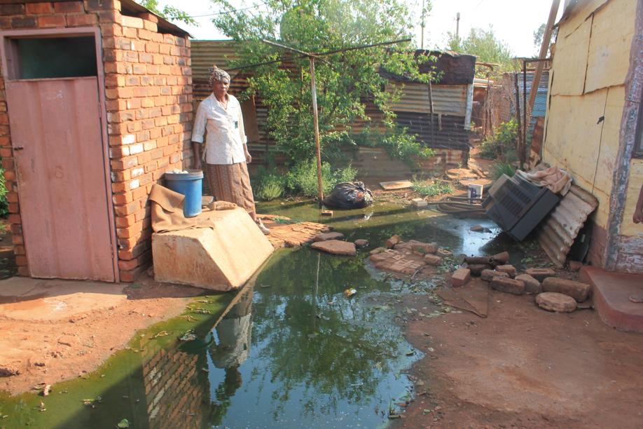 Ms Anna Dube at the stream of sewage in her backyard.