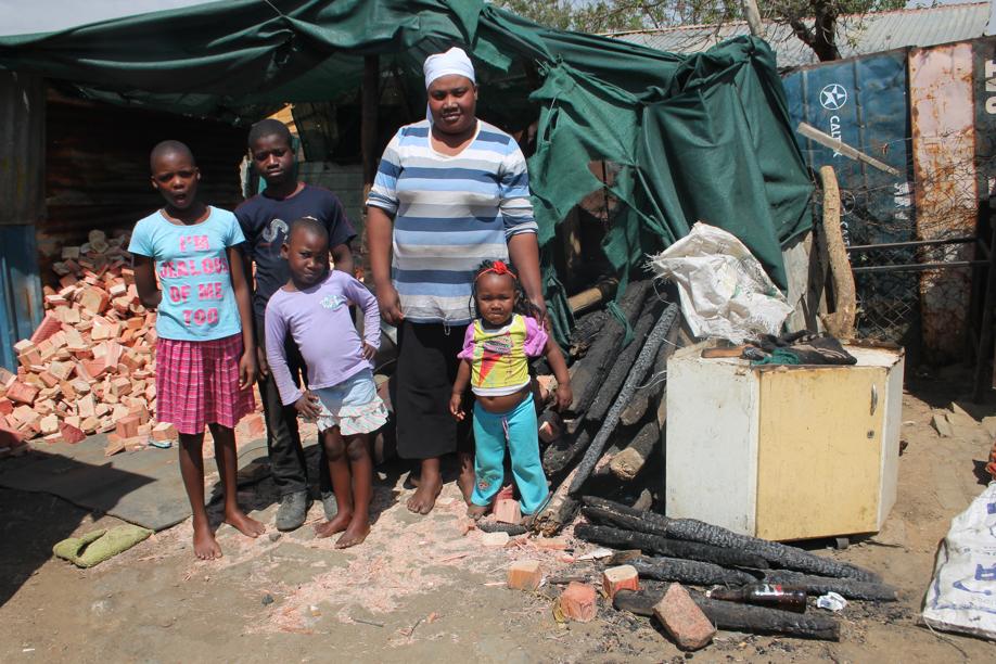 Ms Rosina Mohatla with her children Pumeza (11), Augusto (13), Sibongile (6) and Lucas' twin sister Akodeo in front of some of the remains of their shack that burned out.