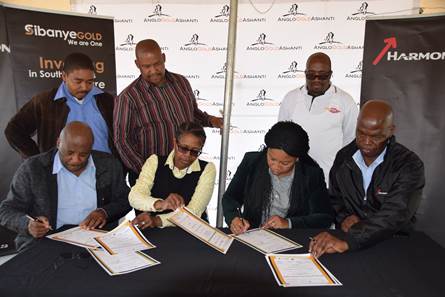 Simeon Moloko, Senior Vice President Sustainability; Duduzile Ratshefola, Community Engagement and Development Manager (Sibanye Gold); Maphefo Mogale-Letsie, Executive Mayor and Mashego Mashego, Executive Director (Harmony) sign the handover certificates while Tsokolo Motsumi from UASA; Moketeka Mohale from AMCU and Stanley Mokgothu from NUM look on.