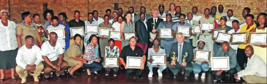 The winners proudly display their certificates and trophies.