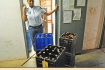 Const. Joyce Malawane with the confiscated liquor.