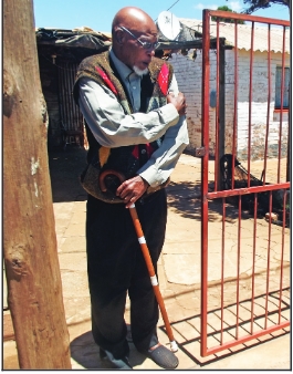 The senior citizen at the gate of his house